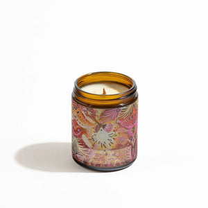 Candle in brown jar with floral aboriginal design on the label