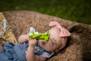 Image of baby holding grasshopper rubber teether