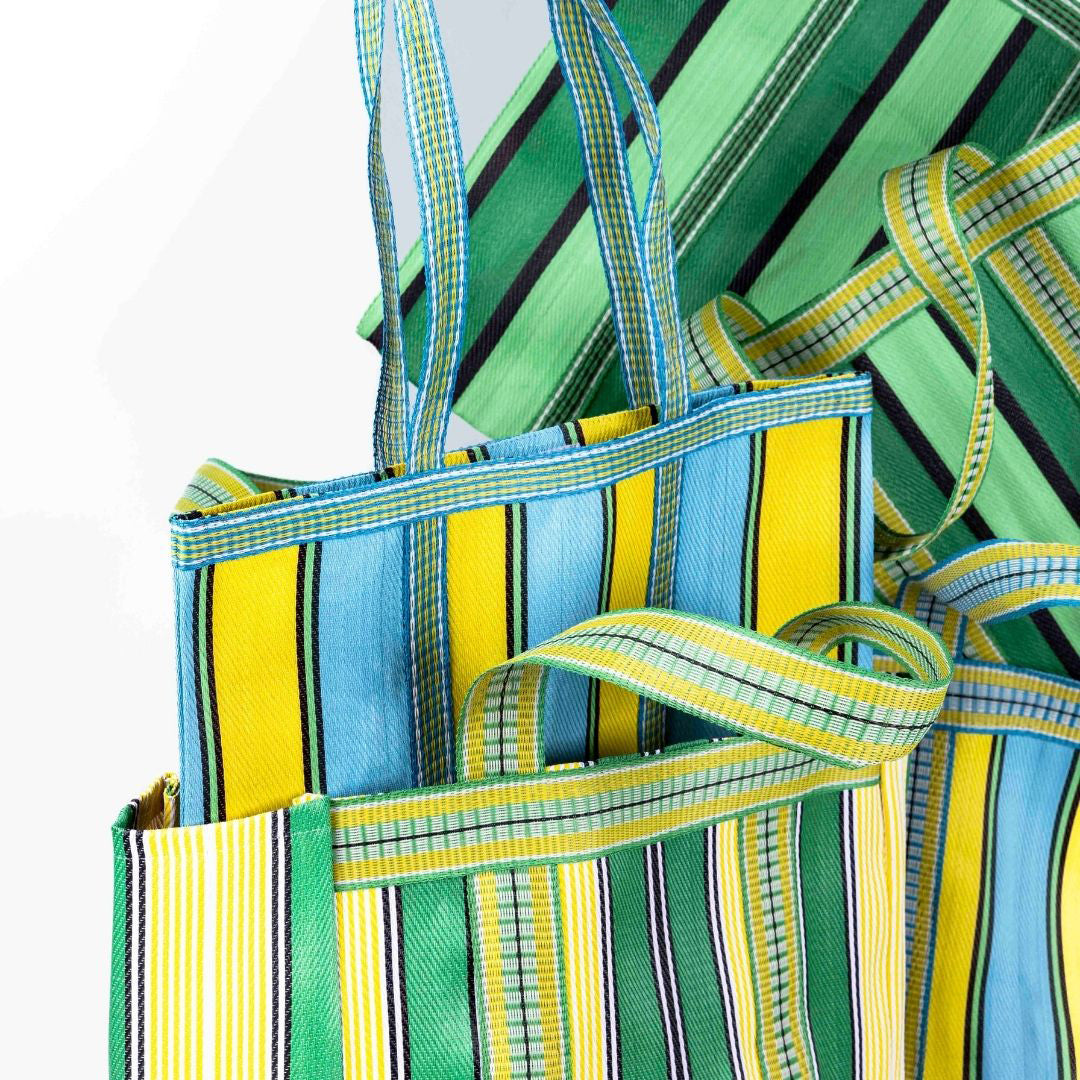 Image of multiple bags including yellow and aqua tote bag