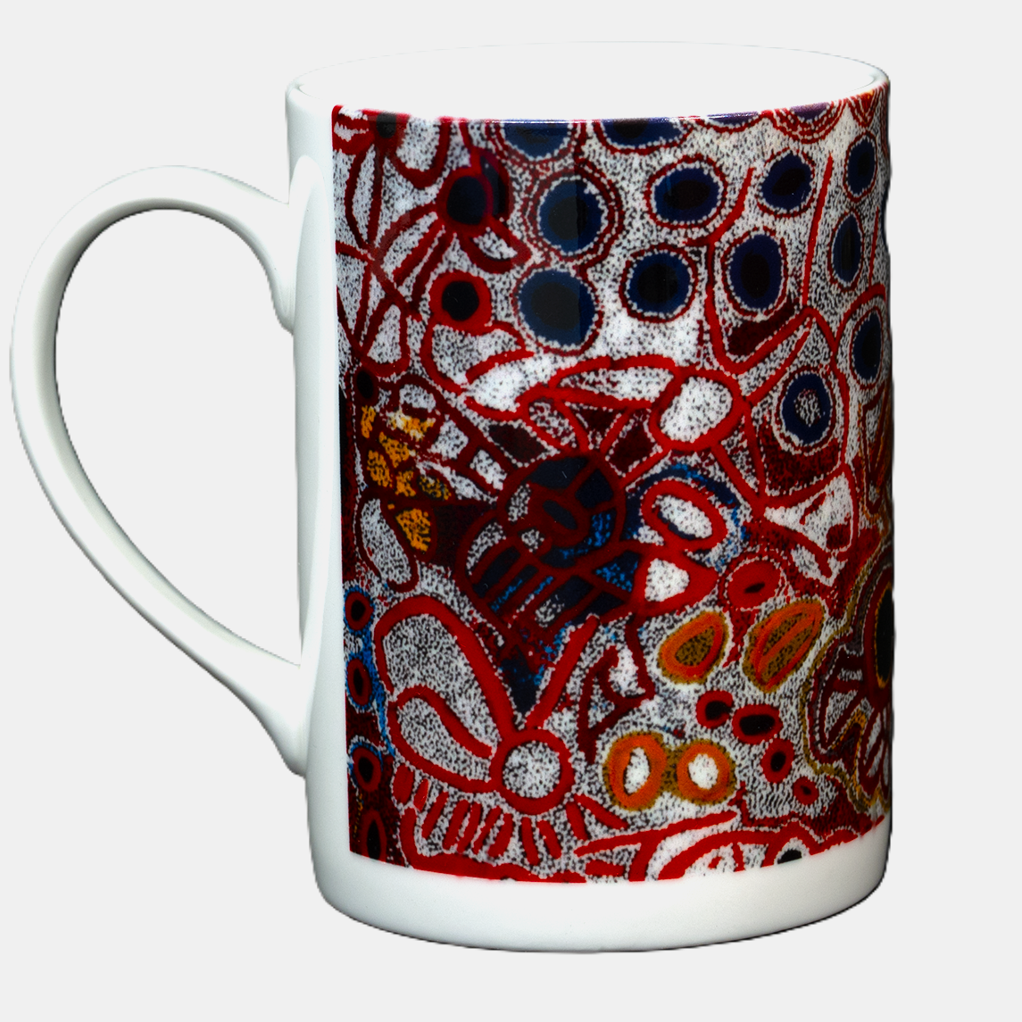 Side view image of Ceramic mug printed with 2010 artwork titled 'Yampil' by Tjawura Woods from the Spinifex Arts Project.