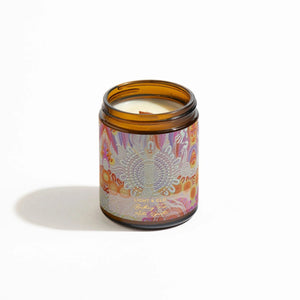 Candle in brown glass jar with lid off and floral label