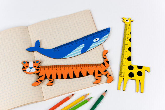 Image of blue whale wooden ruler with notebook and coloured pencils and other novelty rulers