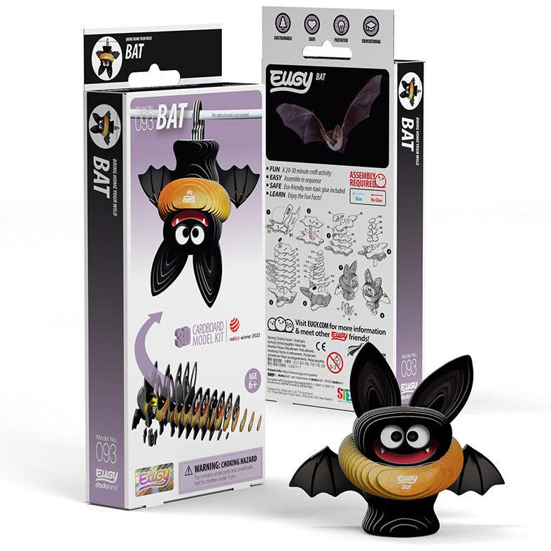 Cardboard model kit for assembling a bat figure, featuring a bat with large eyes, black wings, and an orange body. Packaging includes illustrations, assembly components, and instructions for a craft activity suitable for ages 6 and up.