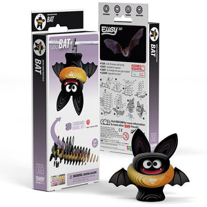 Cardboard model kit for assembling a bat figure, featuring a bat with large eyes, black wings, and an orange body. Packaging includes illustrations, assembly components, and instructions for a craft activity suitable for ages 6 and up.