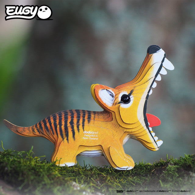 Side view image of EUGY Tasmanian Tiger on log with moss on green background.