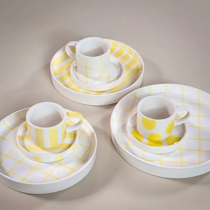 Set of three white ceramic espresso cups with matching saucers and plates, featuring hand-painted yellow dots, stripes, and grids.