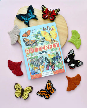 Top view image of butterfly finger puppets with book and wooden board