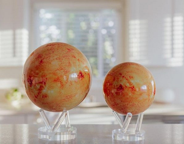 Image of small and large orange Sun Mova Globes on acyrlic stands 
