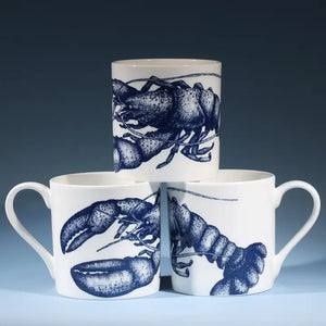 White ceramic mugs with blue lobster design stacked in a pyramid against a dark background.