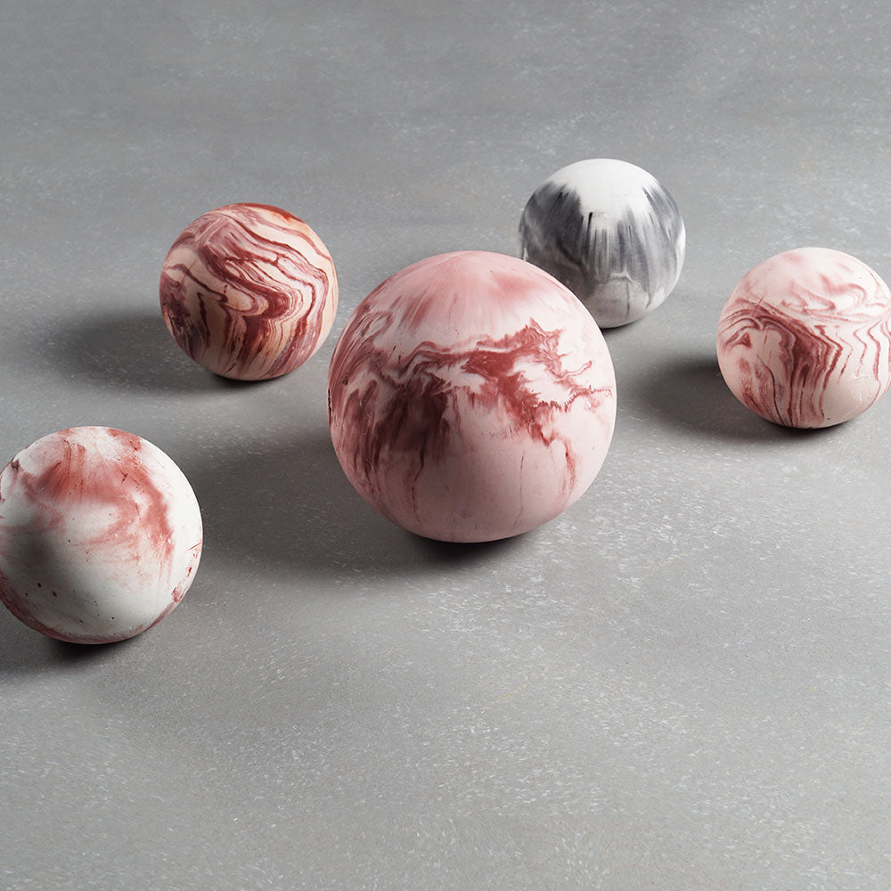 Marble-patterned spherical objects on a gray surface