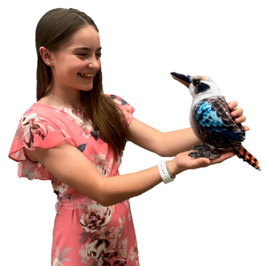 Side view image of young girl holding Kingsley Kookaburra plush toy.