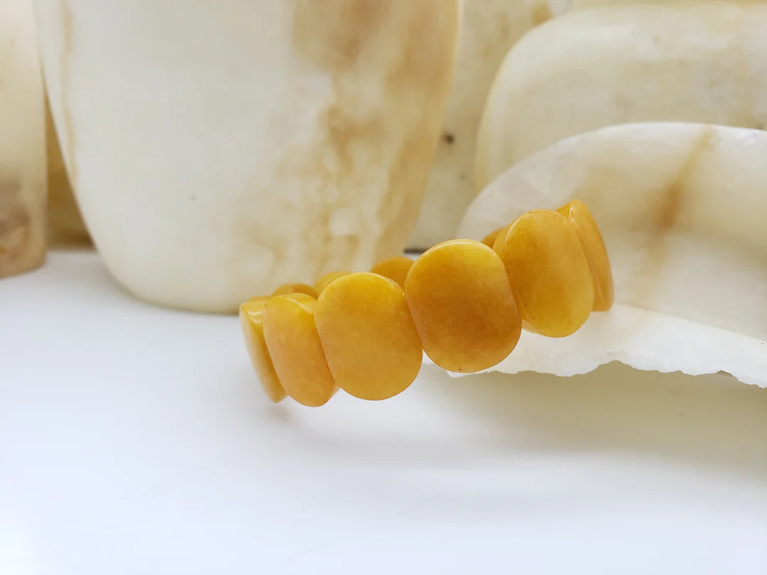 Image of yellow Jade oval shaped beaded bracelet on white background.