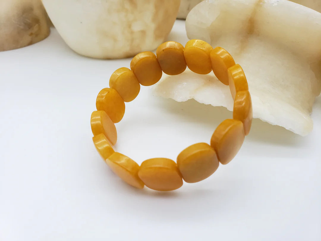 Image of yellow Jade oval shaped beaded bracelet on white background.