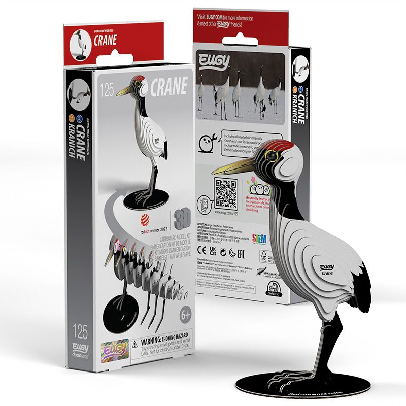 Side view image of EUGY Crane showing 3D carboard model of a red-crowned crane with white body, black neck and legs, and a red patch on the head and packaging on white background.