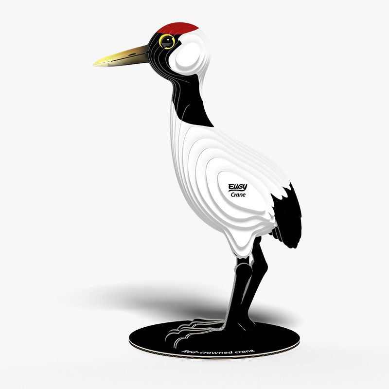 Side view image of EUGY Crane showing 3D carboard model of a red-crowned crane with white body, black neck and legs, and a red patch on the head on white background.