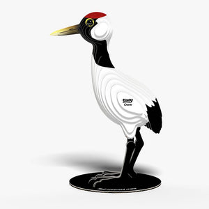 Side view image of EUGY Crane showing 3D carboard model of a red-crowned crane with white body, black neck and legs, and a red patch on the head on white background.