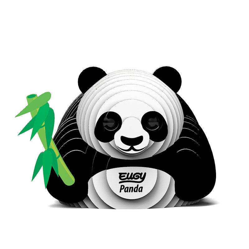 Front view image of black and white 3D Eugy panda model made of layered, recyclable cardboard, sitting upright and holding a green stick of bamboo against a white background.