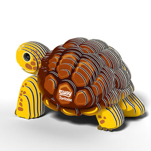 Side to rear view image of Eugy Tortoise, showing tortoise with yellow legs and head and brown shell made from layers of cardboard, on white background.