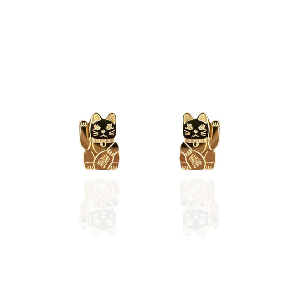 Image of a pair of polished gold stud earrings shaped like lucky cats (Maneki-neko), each with a raised paw and engraved details on the body and face. The earrings are displayed against a white background with a subtle reflection beneath them.