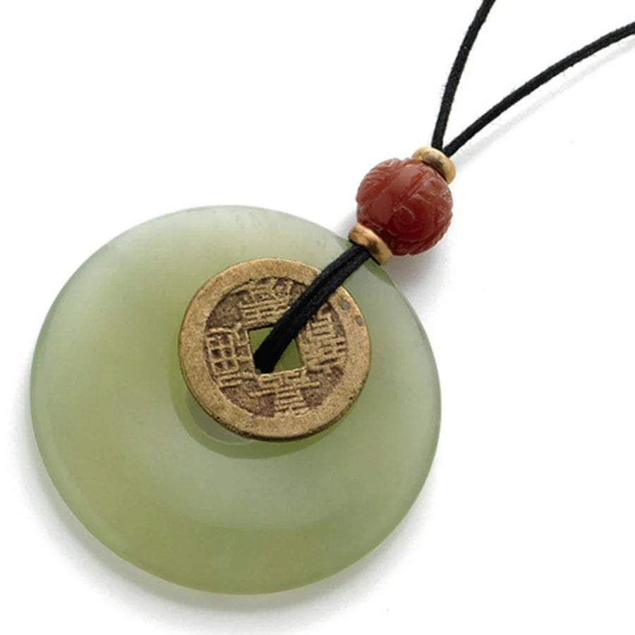 Image of Lime Green Jade Bi Disc with brass Chinese coin on black leather cord with red bead on white background.