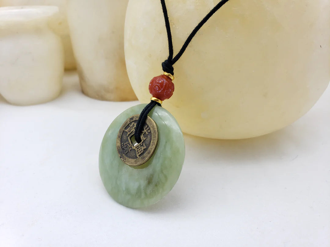 Image of Lime Green Jade Bi Disc with brass Chinese coin on black leather cord with red bead.
