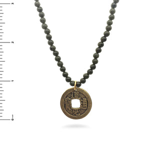 Image of Chinese coin pendant on dark green jade bead necklace on white background.