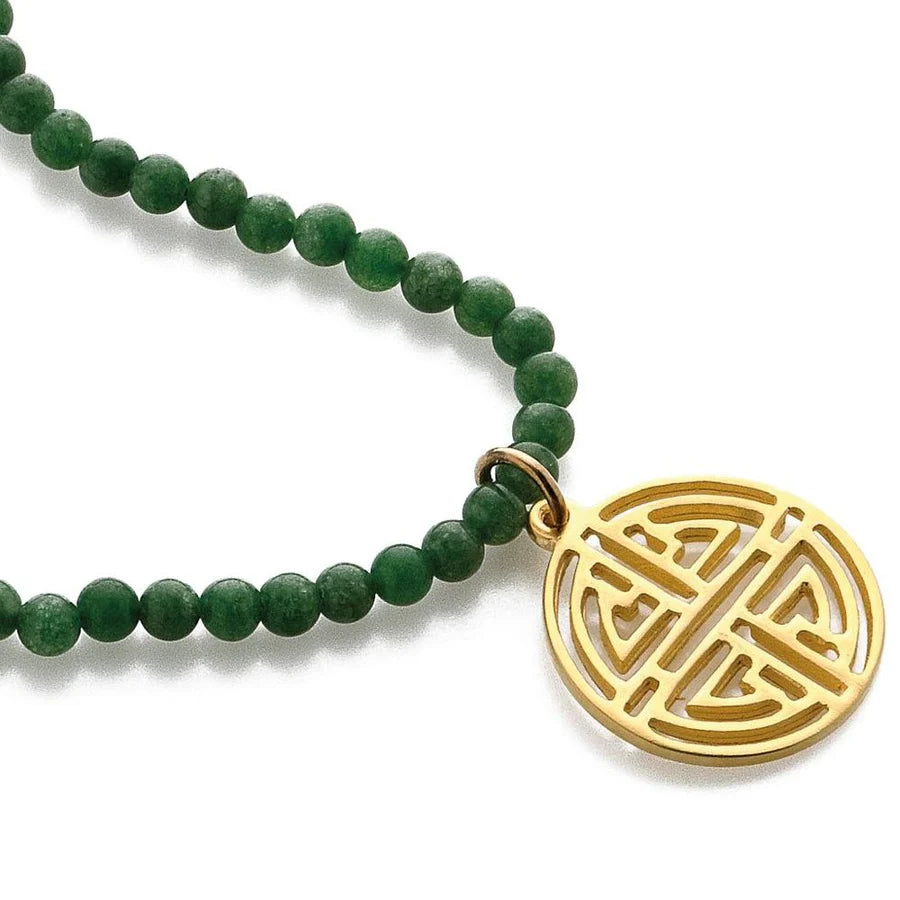 Image of gold Shou symbol pendant on necklace of green beads on white background.
