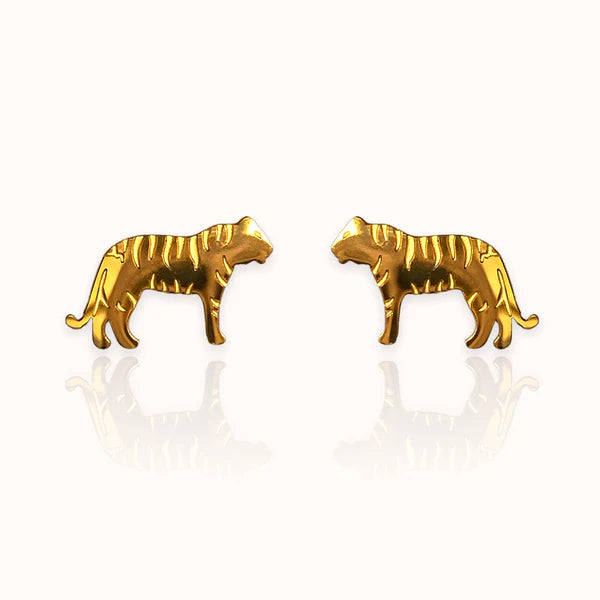Image of a pair of gold-tone stud earrings in the shape of tigers, featuring engraved stripe details and a sleek silhouette. Displayed on an off white background.