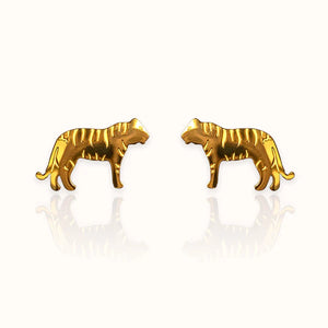 Image of a pair of gold-tone stud earrings in the shape of tigers, featuring engraved stripe details and a sleek silhouette. Displayed on an off white background.