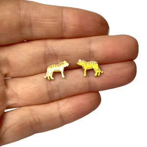 Image of a close-up of a hand holding a pair of gold-tone tiger-shaped stud earrings, showcasing their small size and engraved stripe details.