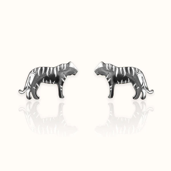 Image of a pair of silver-tone stud earrings in the shape of tigers, featuring engraved stripe details and a sleek silhouette. Displayed on an off white background.