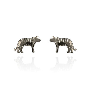Image of a pair of silver-tone stud earrings in the shape of tigers, featuring engraved stripe details and a sleek silhouette. Displayed on a white background with a subtle mirrored reflection beneath each earring.