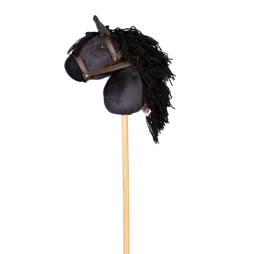 Image of black hobbie horse, showing black plush horse head with black main and brown bridle attached to a pine stock, on white background.