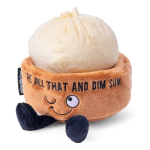 Image of a cute plush toy resembling a dim sum bun in a brown steamer basket with embroidered eyes, a smiling mouth, and black plush feet. The basket has the text 'YOU'RE ALL THAT AND DIM SUM' stitched on it, set against a plain white background.