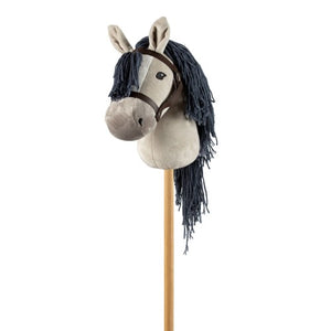Image of grey hobby horse, showing grey plush horse head with dark grey mane and dark brown bridle, attached to pine stick, on white background.