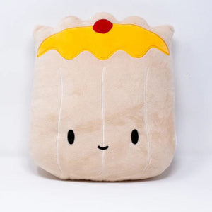Front view image of a plush pillow shaped like a siu mai dumpling, featuring a light beige body with stitched vertical lines, a yellow “wrapper” top with a red dot resembling roe or garnish, and a cute embroidered face with black oval eyes and a small smiling mouth.