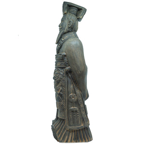 Side view of a 40cm stone statue of a terracotta warrior emperor showing the profile of the figure’s face, tall headdress, long carved robes with dragon and geometric motifs, and hands folded behind the back.