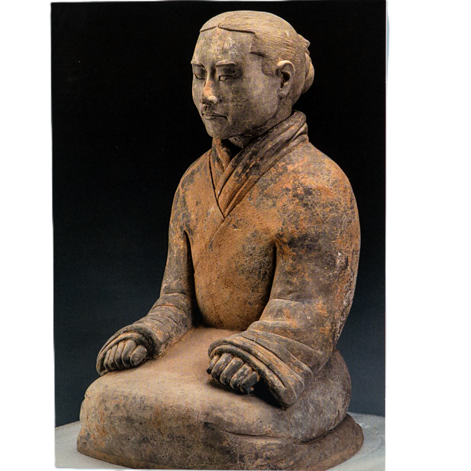 Notecard featuring a weathered seated statue in traditional attire with long sleeves, hands on knees, and blurred face; rustic texture against a dark background.