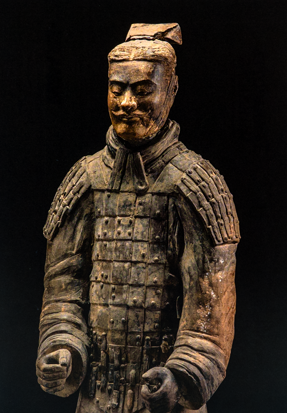 Postcard featuring a terracotta warrior statue in grid-patterned chest armor and intricate shoulder guards; set against a black background.