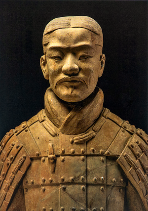 Postcard featuring a close-up of a terracotta warrior statue from the shoulders up, with detailed armor, set against a dark background.
