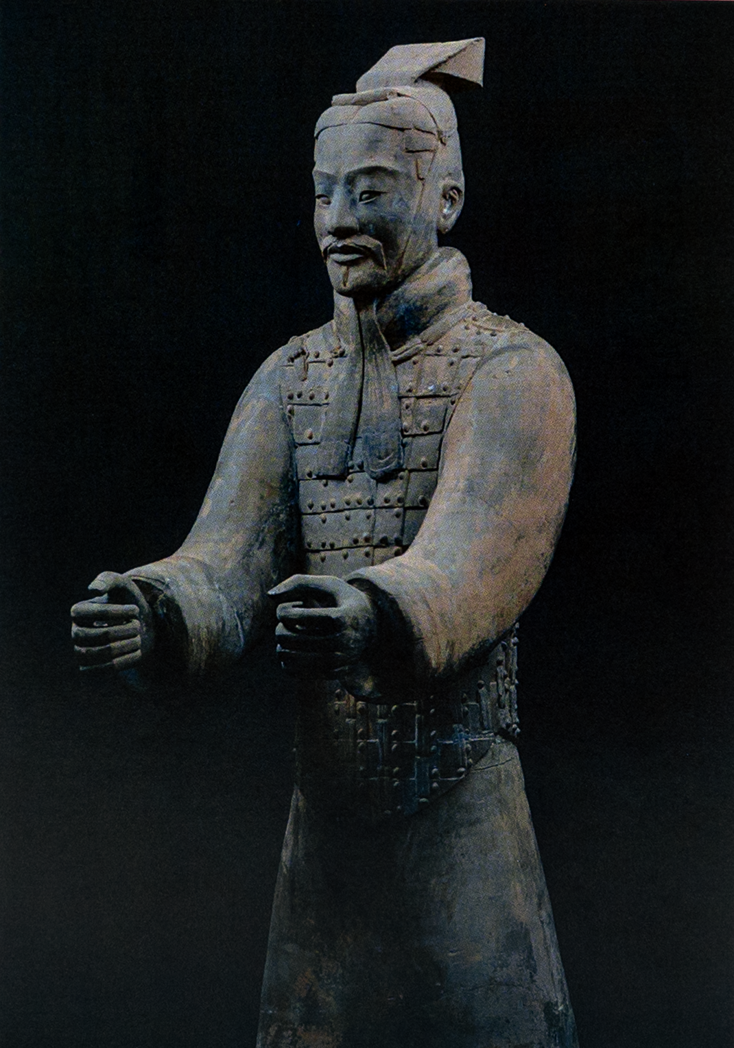 Postcard featuring a Terracotta Warrior statue with arms extended forward, wearing traditional armor and headpiece; set against a dark background.