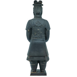 Back view of a terracotta warrior statue wearing traditional armor with a grid-like pattern and decorative shoulder elements. The figure has a topknot hairstyle and stands on a rectangular base.