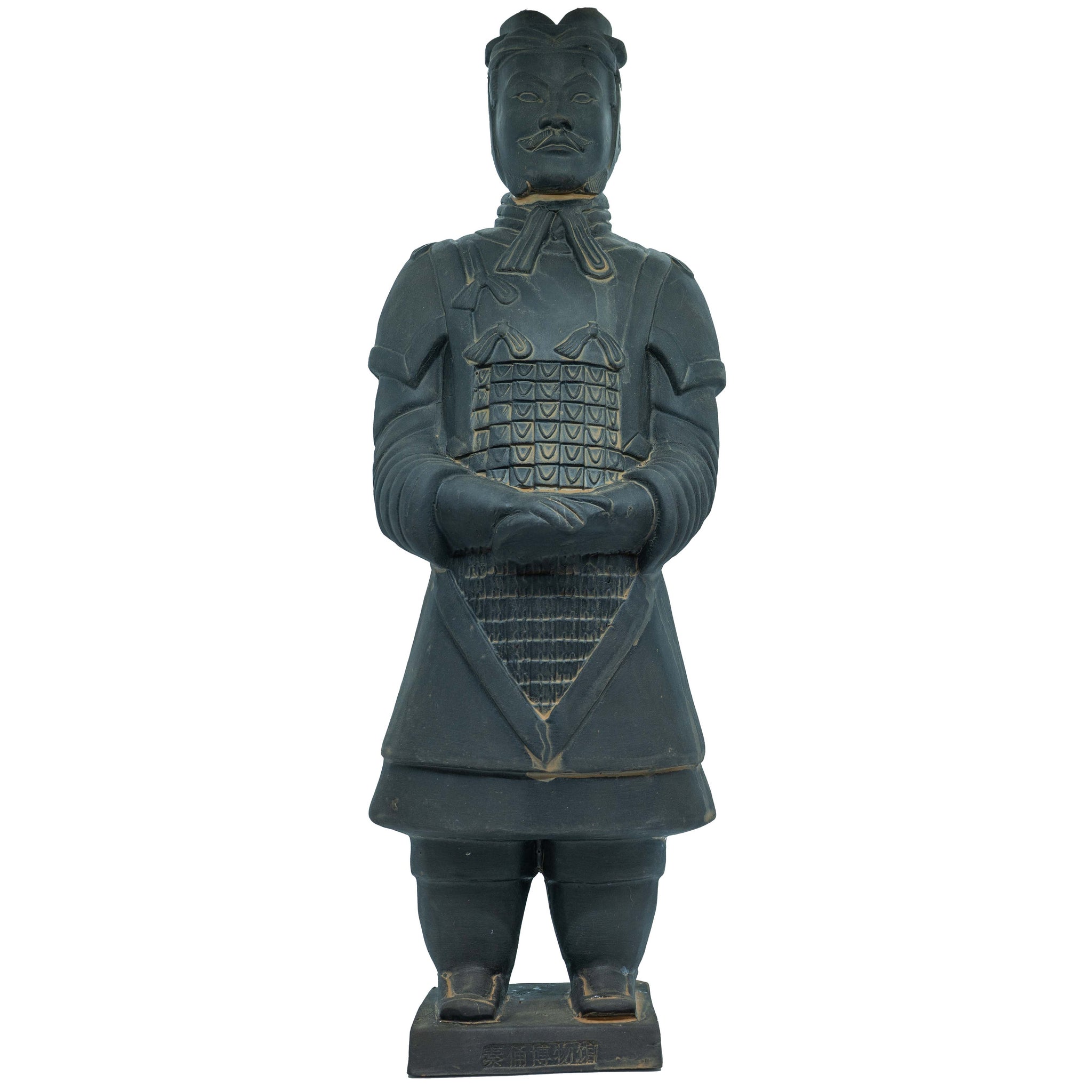Terracotta warrior statue standing upright with hands clasped. The figure wears detailed armor with a grid pattern on the chest and a skirt-like lower section. The face has a mustache and wears headgear. The statue stands on a rectangular base with inscriptions.