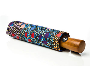 Image of fold up umbrella with floral sleeve and wooden handle. Artwork by Charlene Marshall.