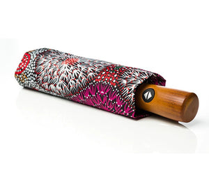 Image of folded umbrealla with floral aboriginal print by Coral Hayes and wooded handle