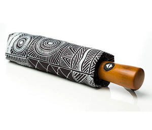 Umbrella folded up with printed sleeve and wooden handle. Artwork by Fiona Purutatameri.